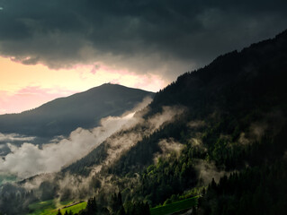 Foggy morning in the mountains, dark cloud, sun