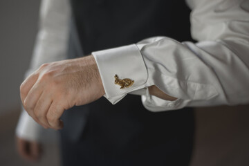 Homme portant des boutons de manchettes en or en forme de lapin 