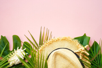 Summer flat lay background. Palm leaves, sea shells and summer cloth on pink background.