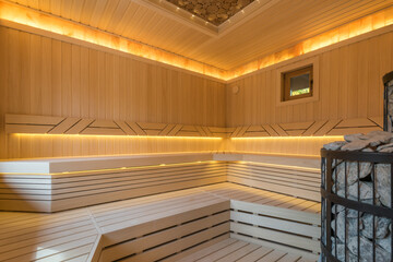 Traditional wooden sauna with beautiful decor. Comfortable benches made of light wood, soft...
