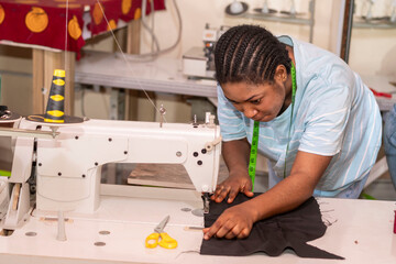tailor working on a sewing machine, stitching fabric together at the shop