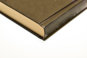 A brown book lies on a white background.