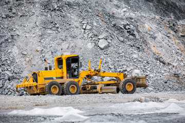 Heavy Big yellow Grader bulldozer at Work in open pit mine of ore