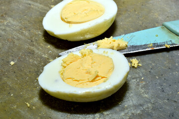 Boiled chicken eggs sliced ​​for salad lie on a cutting board on the table.