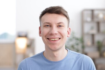 Portrait of cheerful young man at home
