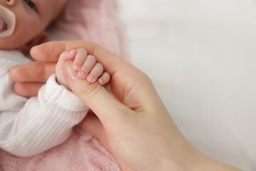 Mother with her little baby on bed indoors, closeup. Space for text