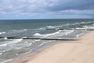 Beach landscape featuring wooden piles used as bank reinforcements, stretching along the shoreline, Trzęsacz, Poland