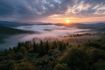Stunning sunrise over misty forested hills with dramatic clouds and sunbeams
