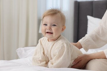 Fototapeta premium Happy little baby and mother on bed indoors, closeup