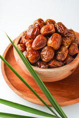 Dates fruit sukari or kurma sukari, in wooden bowl isolated on white background