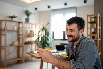 Freelancer enjoying breakfast and video call at home office
