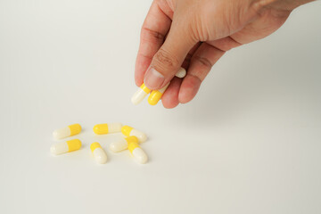 Male hand holding white capsule pill, isolate background, pharmacy, medicine, health care