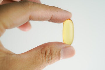 Male hand holding Oil filled capsules, softgel of food supplements, fish oil, omega 3, vitamin E