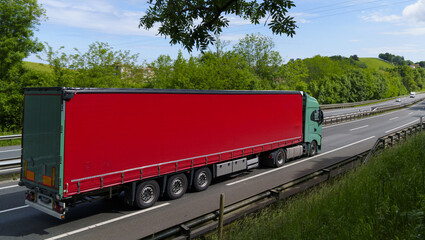 The transport truck is circulating on the highway, facing traffic while carrying supplies.