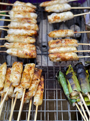 Squid eggs skewers grilled on a charcoal grill for sale at Ang Sila Seafood Market, Thailand.