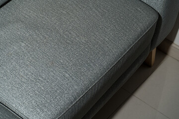Blue fabric texture with white leather sofa in the background