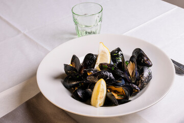 Zuppa di cozze condita con olio, pepe e limone servita in un ristorante di pesce