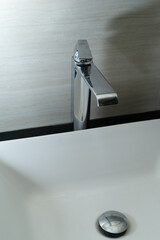 Shiny faucet with water flowing in a clean bathroom sink