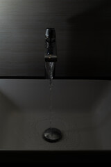 Shiny faucet with water flowing in a clean bathroom sink