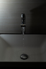 Shiny faucet with water flowing in a clean bathroom sink