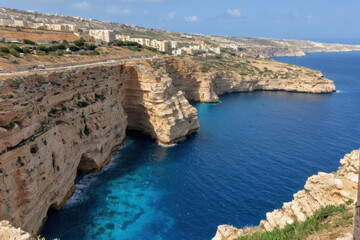 A vast ocean stretches out next to a rocky cliff, with waves crashing against the shore