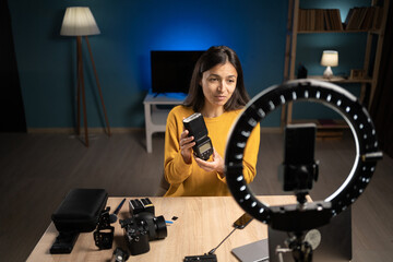 Female photographer content creator using smartphone at home for social media, vlogging and...