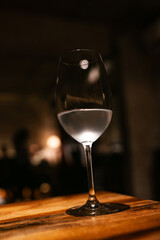 Clear Water in a Wine Glass on Wooden Bar – Minimalist Night Mood