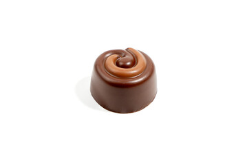 Dark praline with caramel swirl on white background. Dark chocolate praline with decorative swirl...