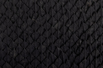 Fototapeta premium arrière-plan rempli d'écailles noires faisant penser à une peau de reptile ou de dragon - fait main - luxe