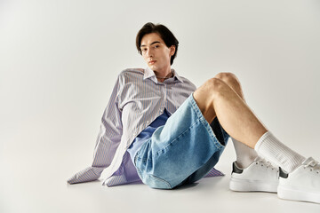 Fashionable genderqueer youth showcases modern style in a minimalist setting