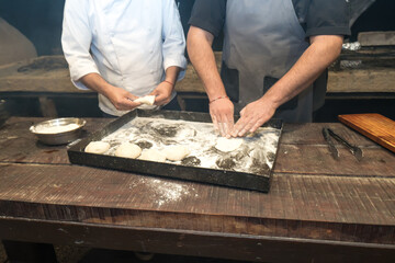 Artisan Bakers Kneading Dough by Hand in Rustic Kitchen
