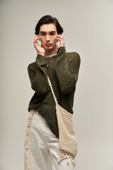 Fashionable non binary youth showcases unique style in creative studio setting