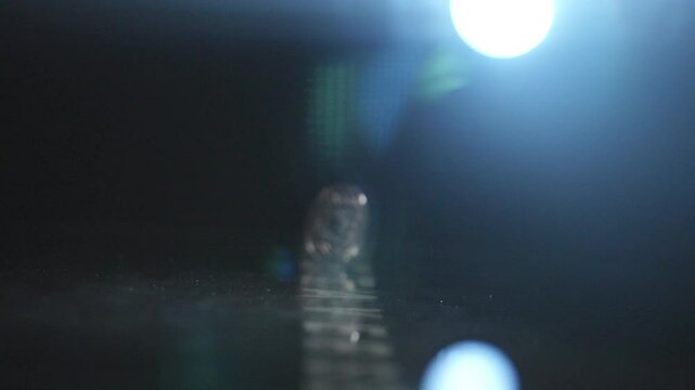 A ETH coin is sitting on a table. The reflection of the coin is visible in the table. The image has a calm and peaceful mood