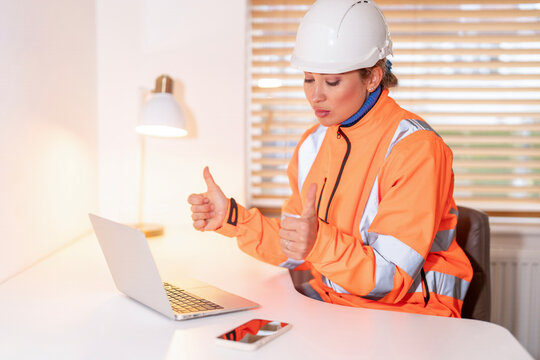 Woman Construction manager reviewing plans and analyzing data while sitting at desk in office