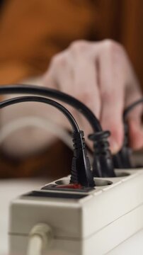 Close-up male hands unplugging plug to save on energy