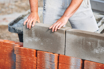 Bricklayer laying bricks on building site