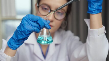 scientist in lab coat examines blue liquid in flask, showcasing precision and focus in her work. - Powered by Adobe