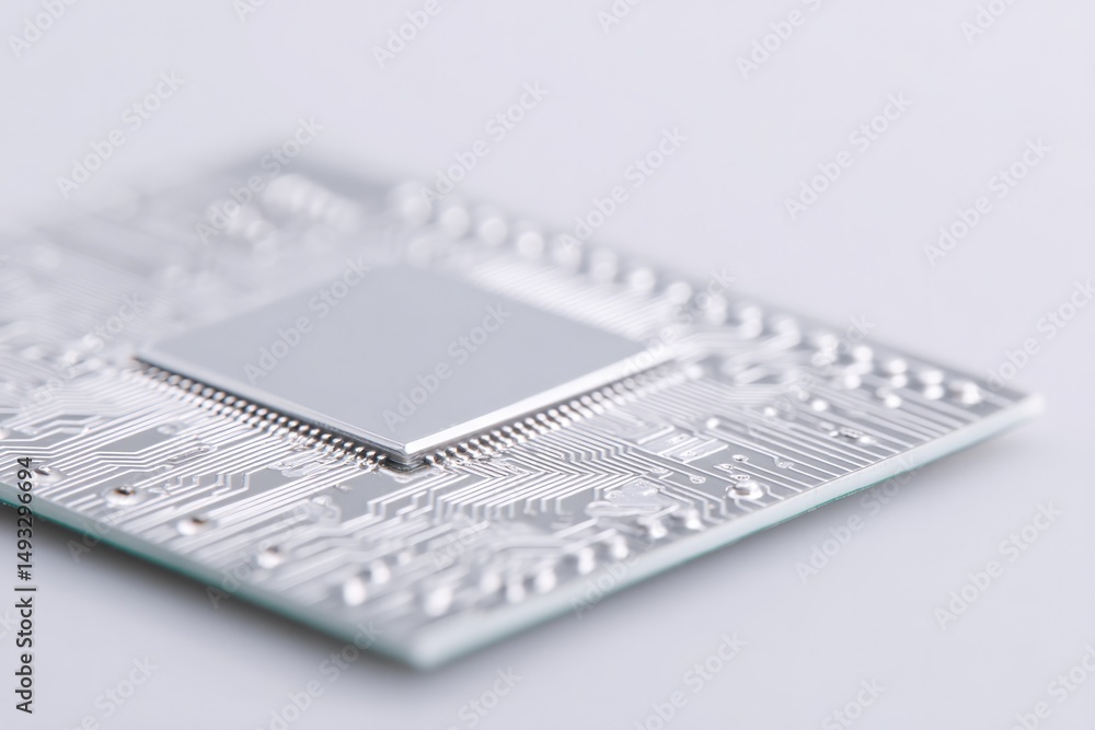 Poster sleek and shiny futuristic circuit board lying flat on white surface surrounded by generous amount o