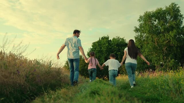 Family game Concept, father mother daughter son fun running. Happy family team, children, parents, run together in park on grass. Children dream, mom dad children in nature. Weekend, play, holiday