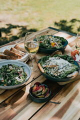 A field of white flowers with green leaves. The flowers are scattered 