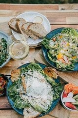 A table with a variety of salads and breads, including a blue salad with carrots