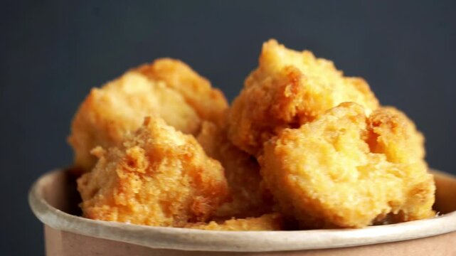 Crispy tofu (tahu crispy) in a paper bowl. Indonesian street food.