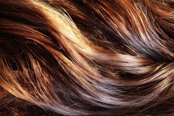 Rich brown hair with natural highlights flows in wavy pattern, creating textured and shiny appearance. close up view emphasizes smoothness and vibrant color of strands