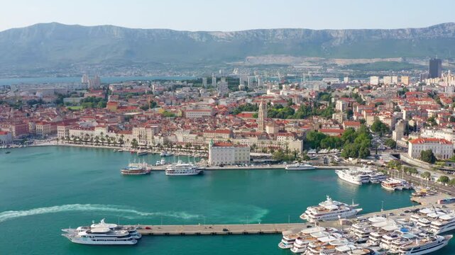 Establishing Aerial view of Split historic old town in Croatia with red roof buildings and vibrant waterfront with boats. Perfect for travel, architecture, and sea coastal scenery. 4K panoramic shot