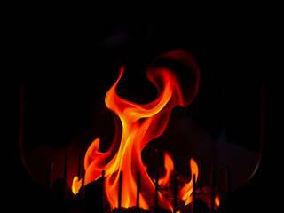 Abstract burning inferno flame on a black background, a fiery blaze of isolated warm light and danger