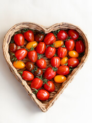 Herzvolle Frische. Bunt gemischte frische und knackige Tomaten im Herz Korb.
