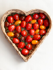 Herzvolle Frische. Bunt gemischte frische und knackige Tomaten im Herz Korb.