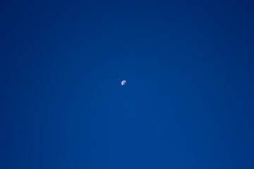 Crescent moon against a clear blue sky, highlighting space, nature, or abstract.

