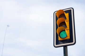 Green traffic light signaling go on a clear day with blue sky and minimal clouds in the background