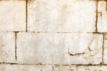  Textured white stone wall with visible cracks and imperfections, ideal for backgrounds and design...